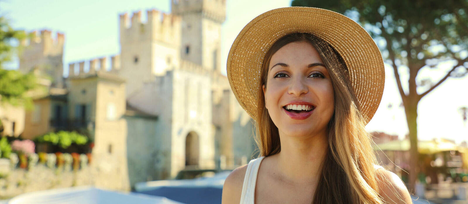 Porträt einer lächelnden Touristenin mit Schloss Sirmione © zigres - stock.adobe.com