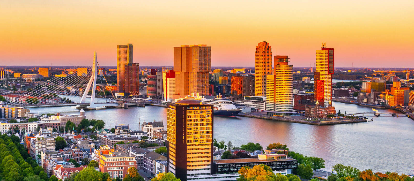 Luftaufnahme der Erasmusbrücke und der Skyline von Rotterdam bei Sonnenuntergang © dudlajzov - stock.adobe.com