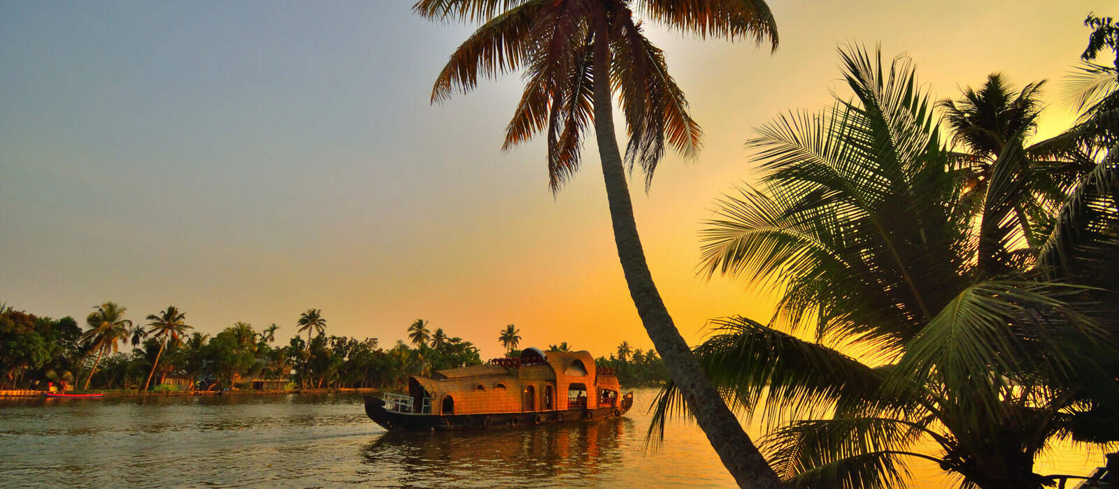 A boat sailing on Kerala backwaters during sunset. © saurav005 - stock.adobe.com