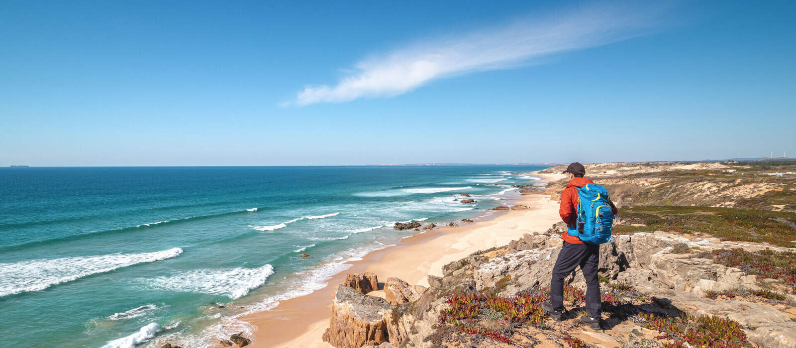 Traveller enjoys the view of the sandy beach of Praia do Malhao Sul on the Atlantic coast near Vila Nova de Milfontes, Odemira, Portugal. In the footsteps of Rota Vicentina. Fisherman trail © Fauren - stock.adobe.com