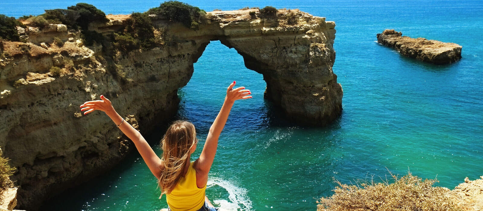 Frau genießt den Panoramablick von oben auf die Küste der Algarve © Evrymmnt - stock.adobe.com