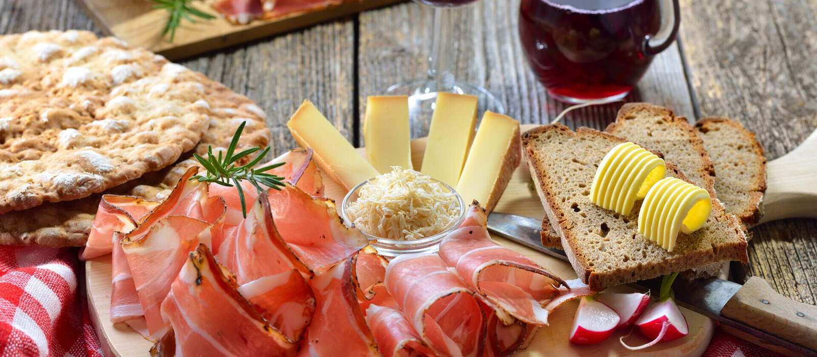 Südtiroler Bauernspeck mit Kren und reifem Bergkäse, dazu Landbrot sowie Rotwein © kab-vision - stock.adobe.com