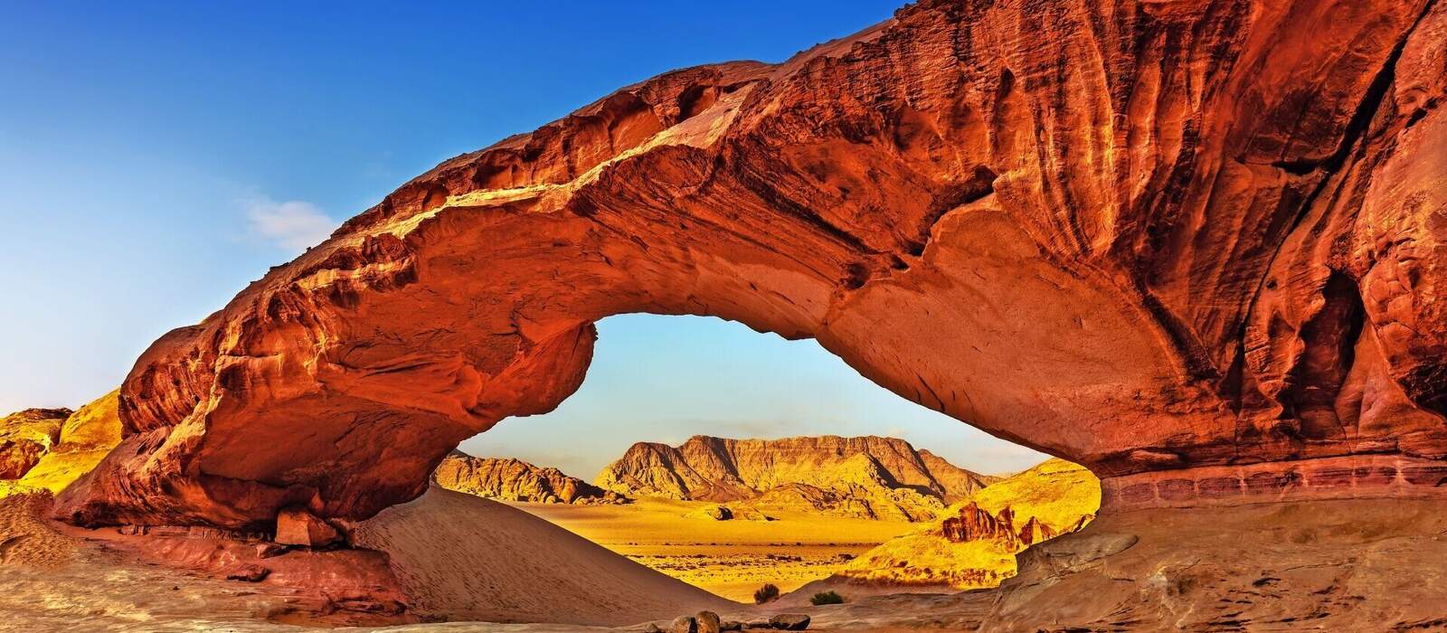 Blick durch einen Felsbogen in der Wüste von Wadi Rum © tobago77 - stock.adobe.com