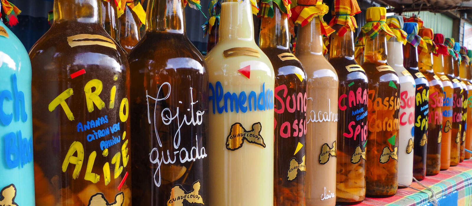 Rum-Flaschen auf einem Marktstand auf Guadeloupe © OkFoto.it - stock.adobe.com